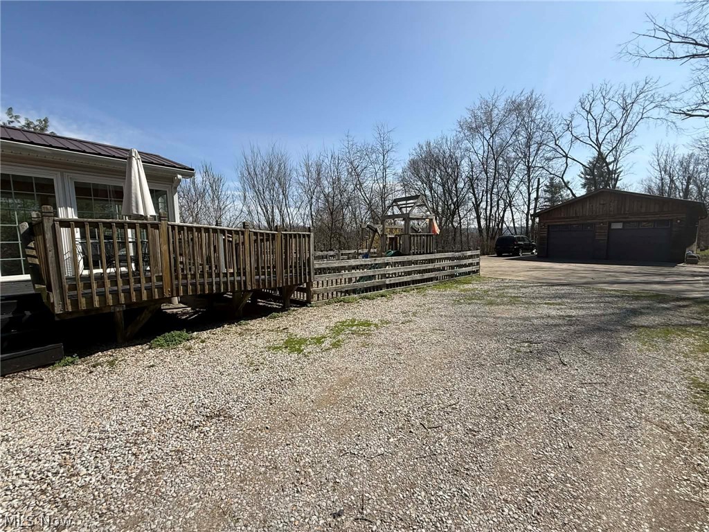 7170 Old Town Road Mount Perry, OH 43760 - Photo 33 of 41 View of yard featuring a deck, a detached garage, and an outdoor structure
