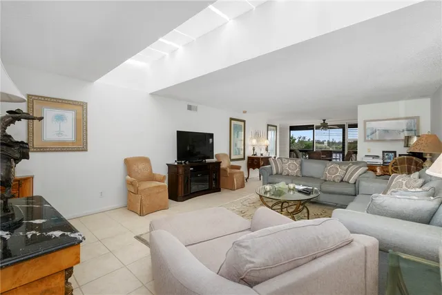 a living room with furniture a flat screen tv and kitchen view