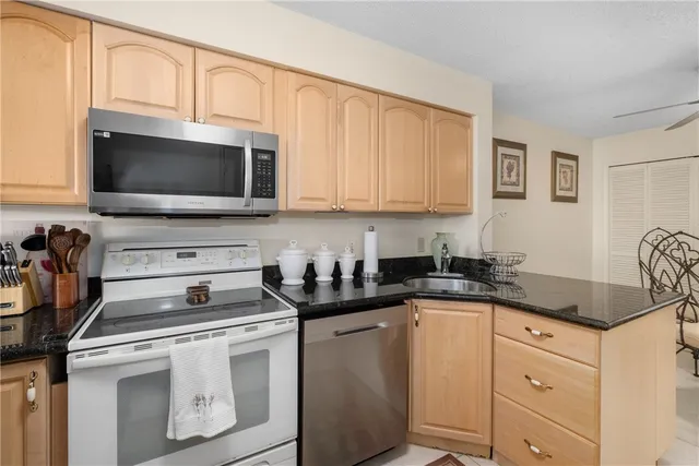 a kitchen with granite countertop a sink a stove and cabinets