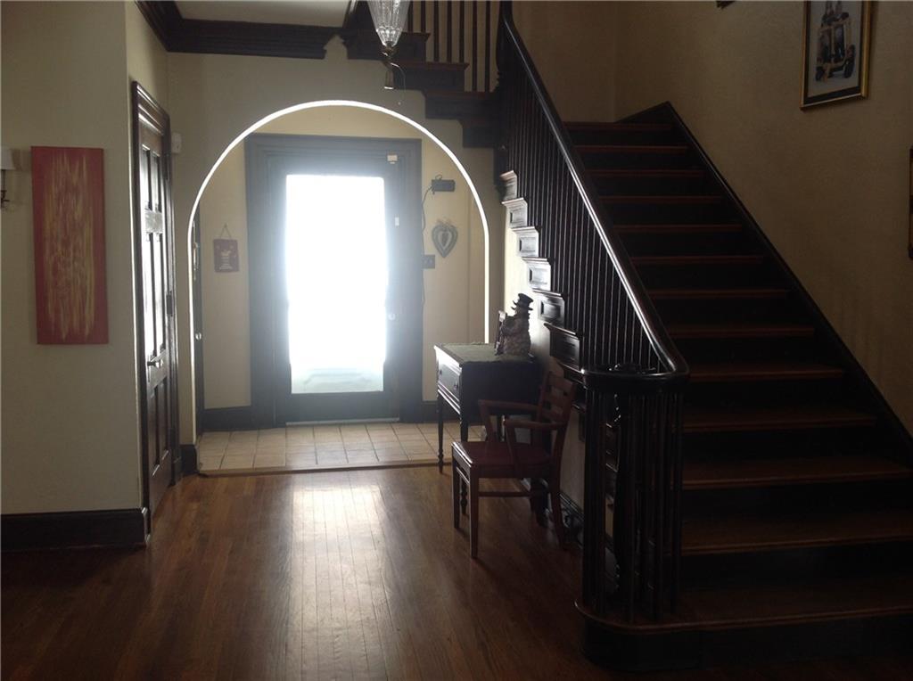 Walk under the arch way as you fall in love with this entry way.  Original woodwork and hard wood floors accent along with the wide staircase that leads to the second floor. 