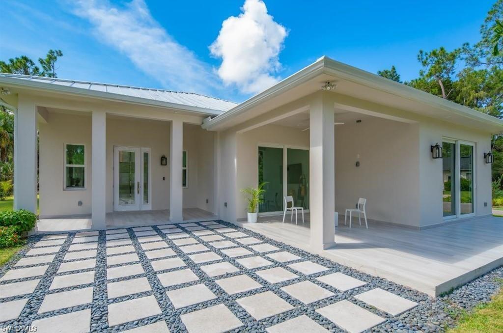 3740 3rd Avenue Southwest Naples, FL 34117 - Photo 13 of 16 Back of house featuring stucco siding, a patio, a metal roof, and french doors