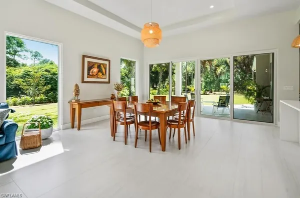a dining room with furniture and a floor to ceiling window
