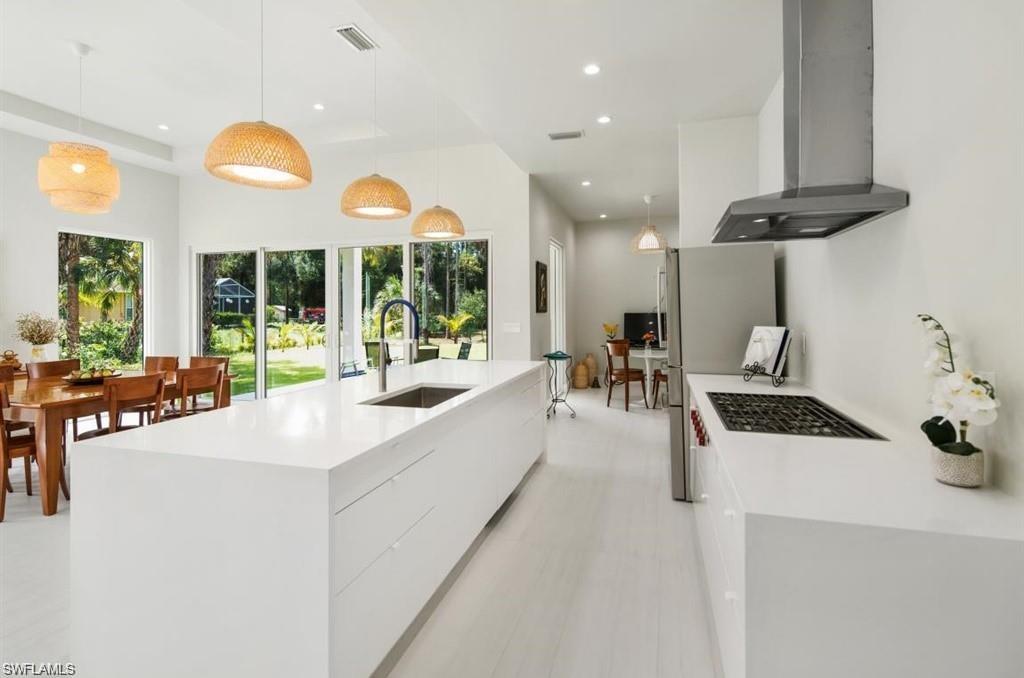 3740 3rd Avenue Southwest Naples, FL 34117 - Photo 7 of 16 Kitchen featuring pendant lighting, range hood, modern cabinets, light stone counters, and recessed lighting