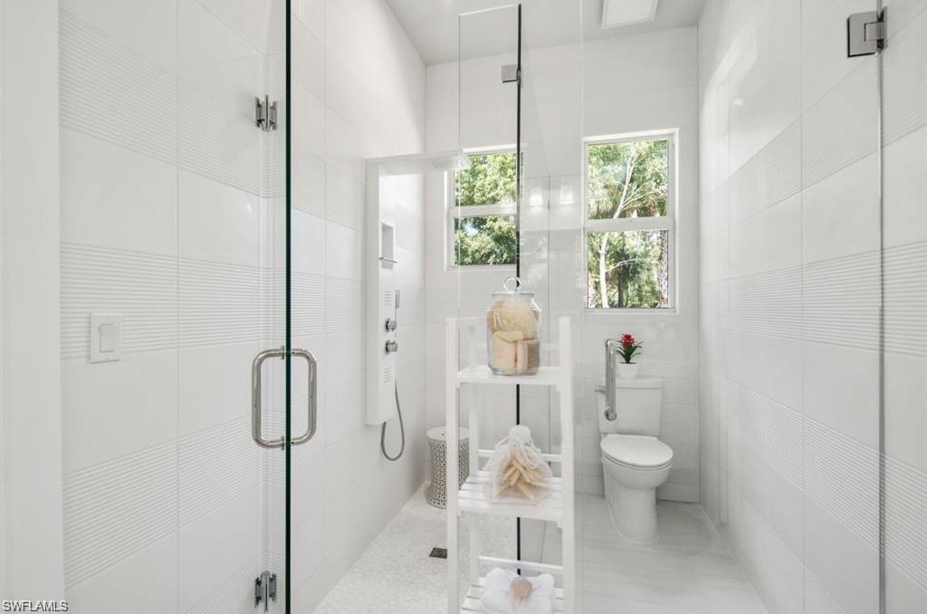 3740 3rd Avenue Southwest Naples, FL 34117 - Photo 10 of 16 Bathroom featuring a shower stall and tile walls