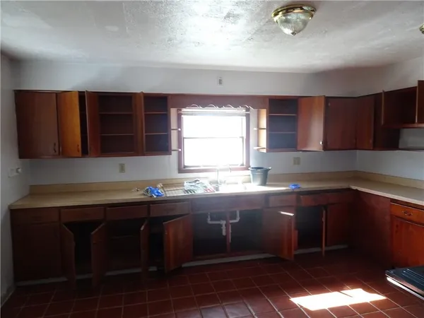 a kitchen with a sink window and cabinets