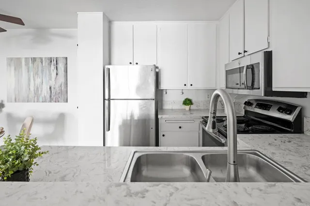 a kitchen with a refrigerator a stove and a sink with wooden floor