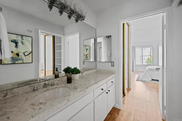 a en suite bathroom with a granite countertop sink and a mirror