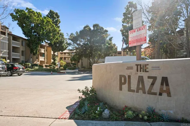 a sign board with buildings in the background
