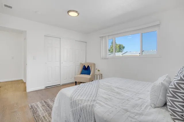 a bedroom with a bed and a painting on the wall