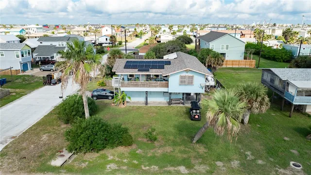 an aerial view of residential houses with outdoor space and trees
