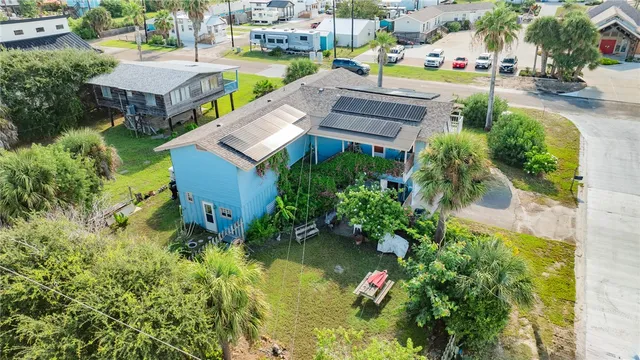 an aerial view of a house with a garden and lake view