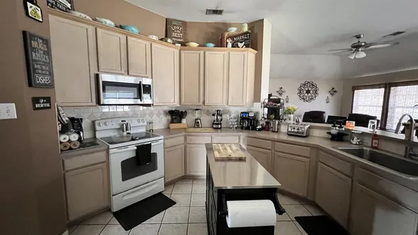 a kitchen with a sink appliances cabinets and furniture