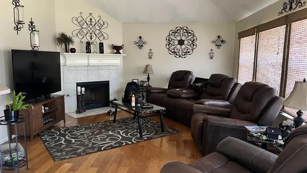 a living room with furniture a flat screen tv and a fireplace