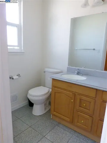 a bathroom with a granite countertop toilet and sink