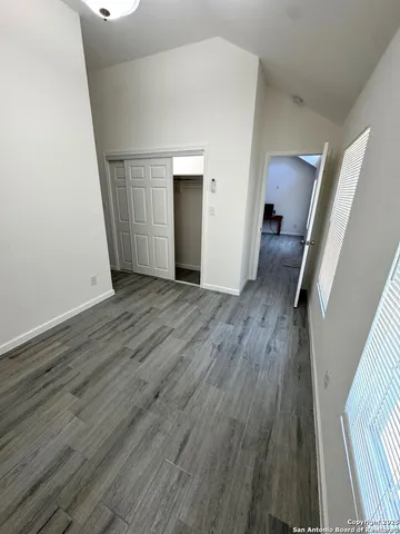 an empty room with wooden floor and stairs