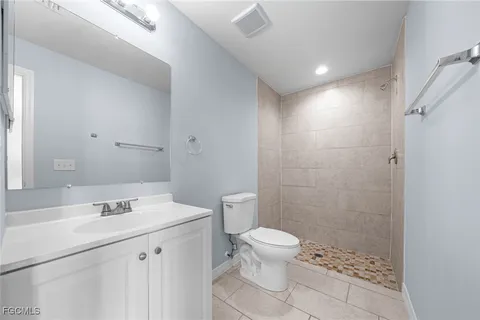 a bathroom with a sink a toilet a shower and a mirror