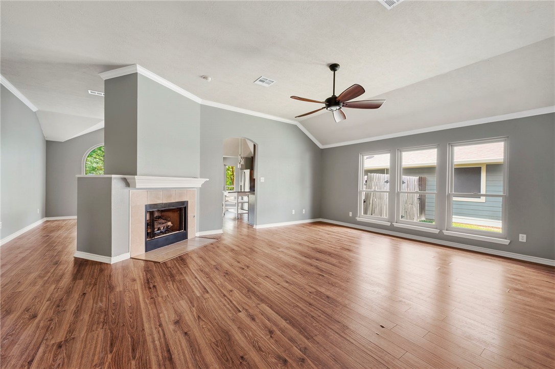 1700 Kingsgate Drive Bryan, TX 77807 - Photo 5 of 21 a view of an empty room with wooden floor fireplace and a window