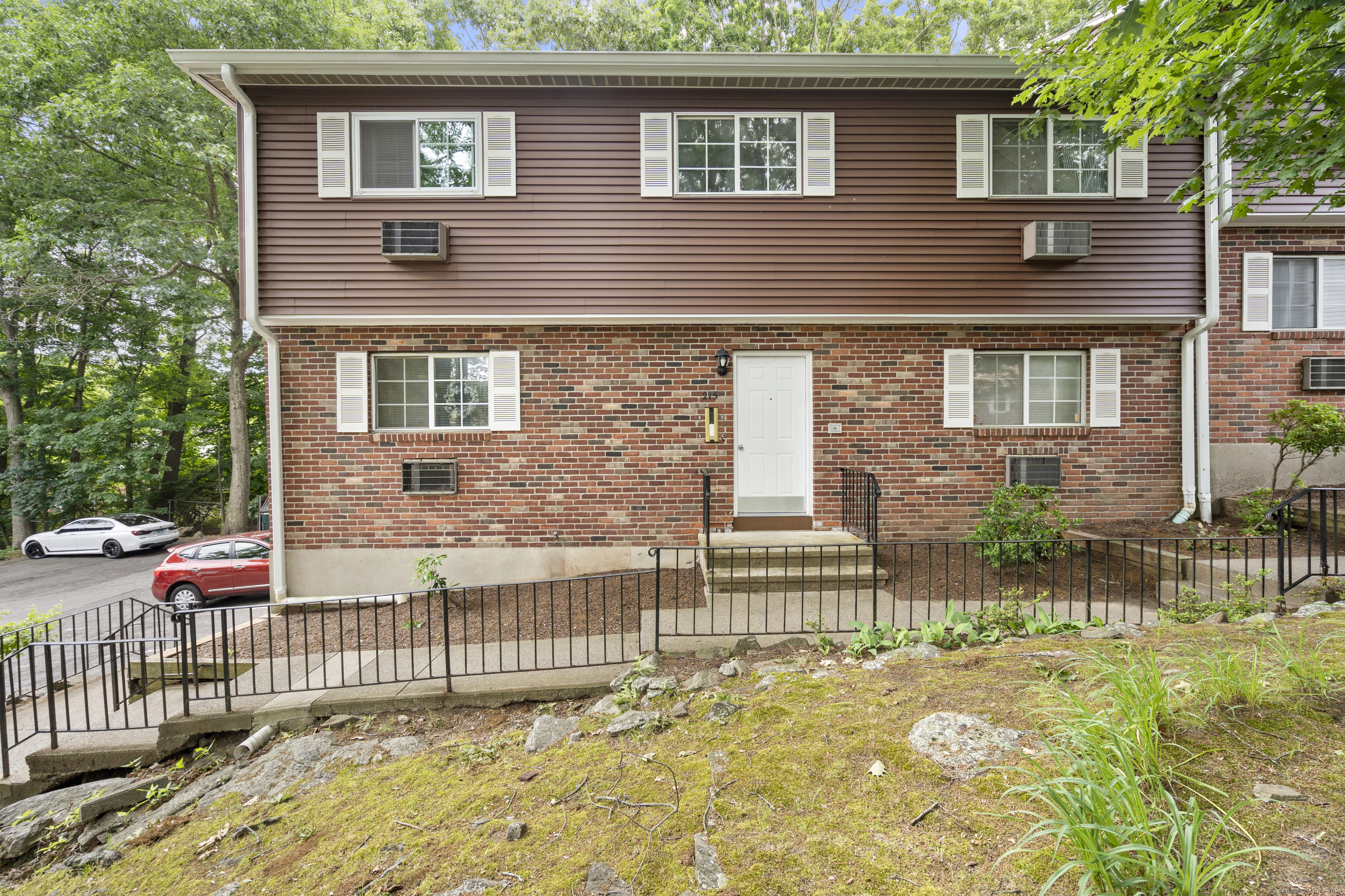 a brick house that has a small yard and a table and chairs