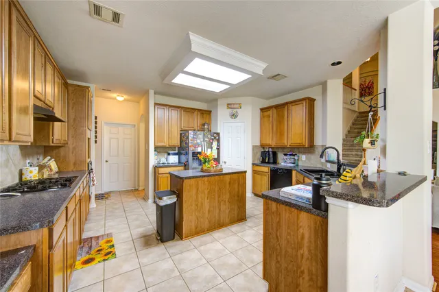a kitchen with stainless steel appliances kitchen island granite countertop a sink and cabinets