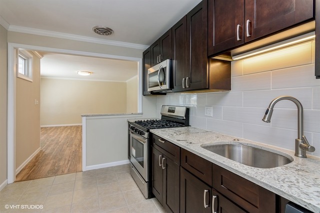 170 George Road Wheeling, IL 60090 - Photo 4 of 11 a kitchen with stainless steel appliances granite countertop a sink stove and microwave