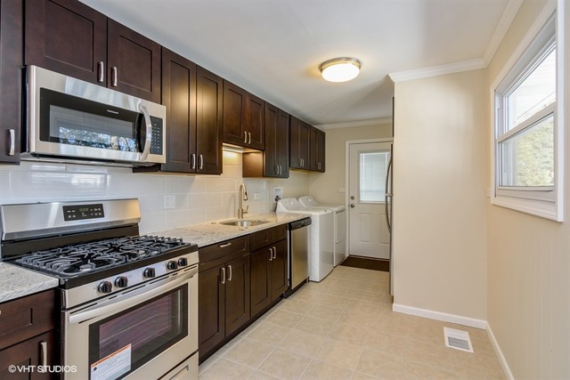 170 George Road Wheeling, IL 60090 - Photo 6 of 11 a kitchen with stainless steel appliances a stove microwave and sink