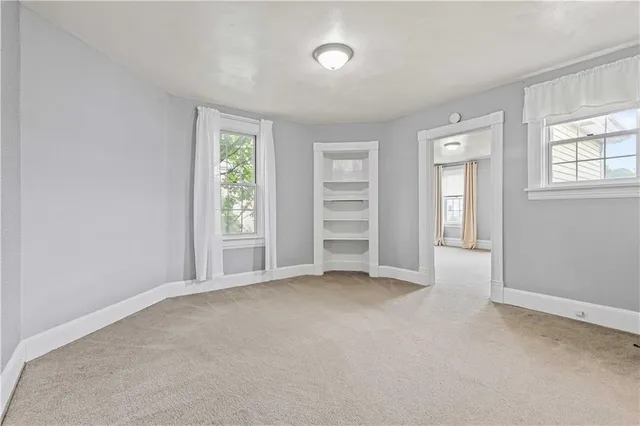 an empty room with windows and a flat screen tv