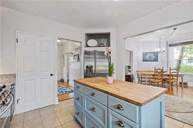 a kitchen with kitchen island a counter top space a sink stainless steel appliances and cabinets