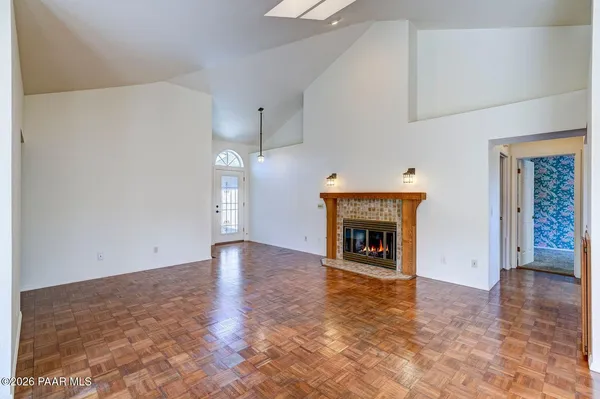 a view of an empty room with window and fire place