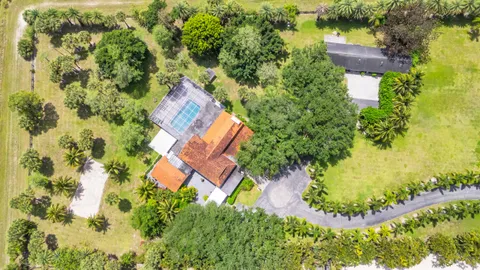 an aerial view of a house with a yard swimming pool and outdoor seating