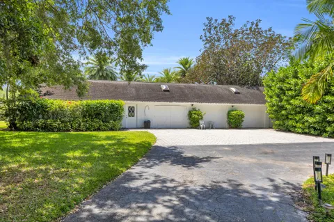 a front view of a house with a yard and potted plants