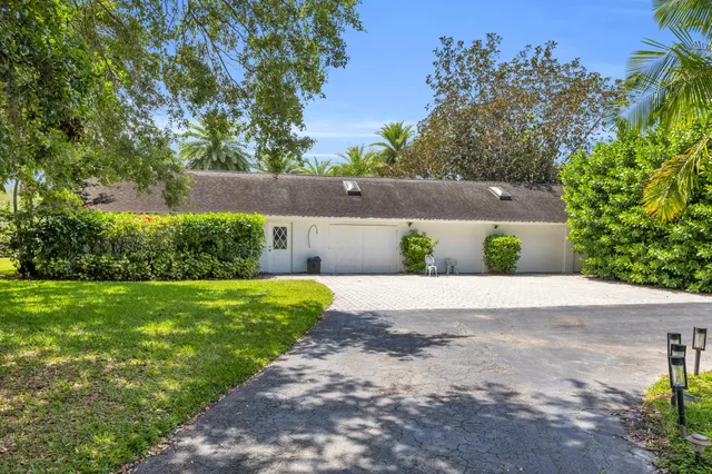a front view of a house with a yard and potted plants