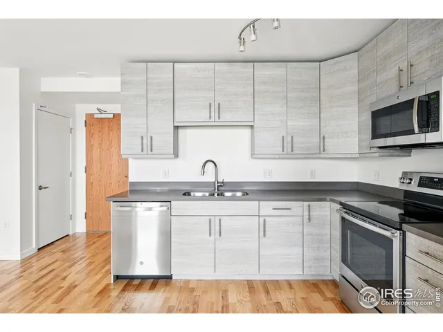 a kitchen with granite countertop a refrigerator and a stove top oven