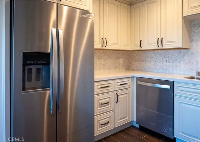 a kitchen with stainless steel appliances granite countertop white cabinets and a stove top oven
