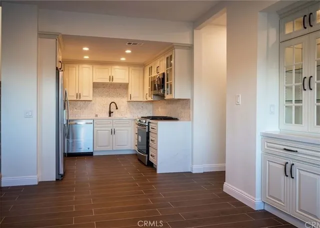 a view of a kitchen with wooden floor and cabinets