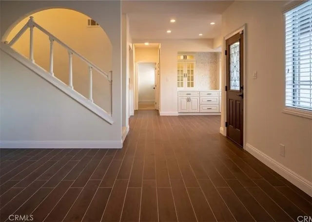 a view of a hallway with wooden floor and entryway