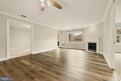 a view of an empty room with a window and fireplace