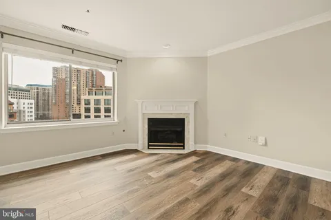 an empty room with windows and fireplace