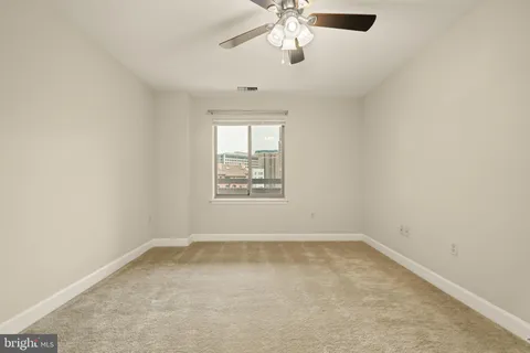 an empty room with windows and fan