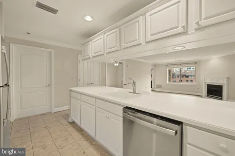 a kitchen with stainless steel appliances cabinets a wooden floor and a sink