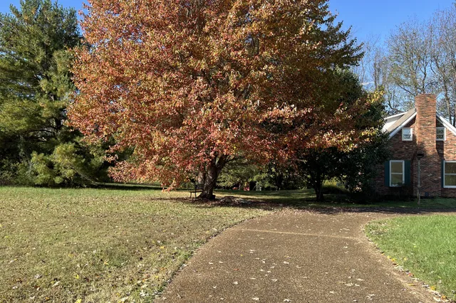 a view of a stone house with a yard