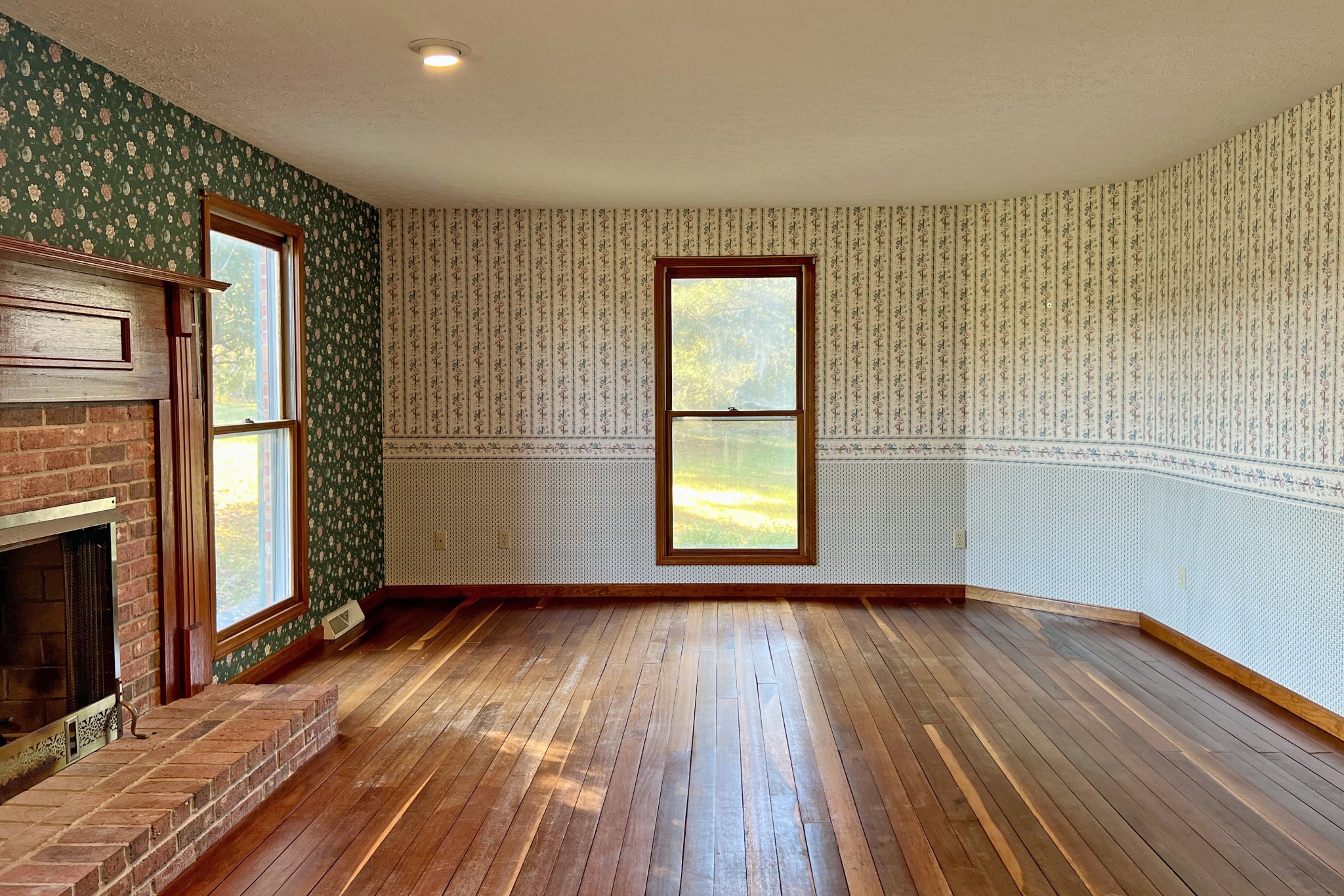 1015 Salem Road Franklin, KY 42134 - Photo 6 of 61 a view of an empty room with wooden floor fireplace and a window
