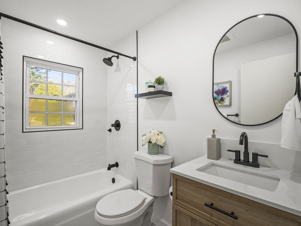 9 Elm Street, Unit 1 Acton, MA 01720 - Photo 23 of 29 a bathroom with a sink a toilet and a mirror