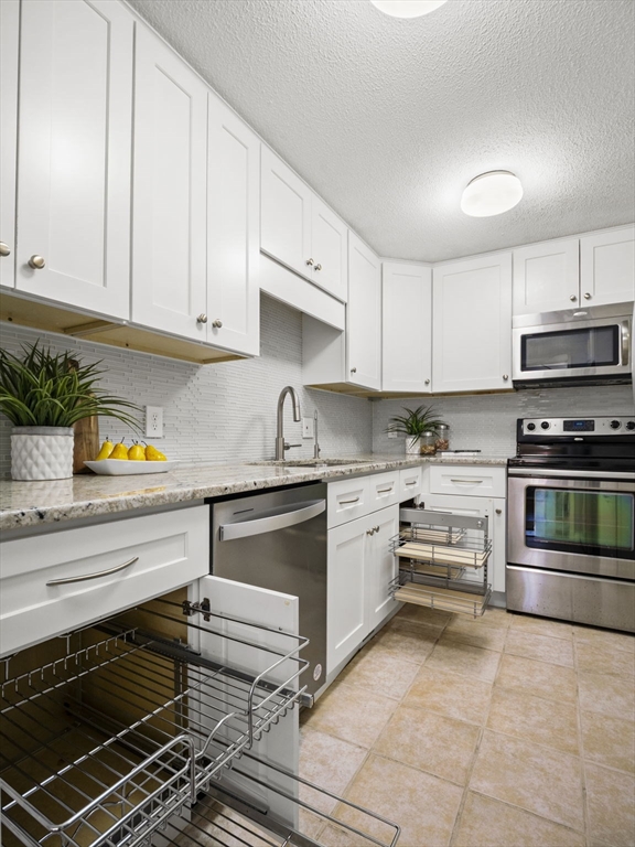 9 Elm Street, Unit 1 Acton, MA 01720 - Photo 9 of 29 a kitchen with granite countertop a stove and cabinets