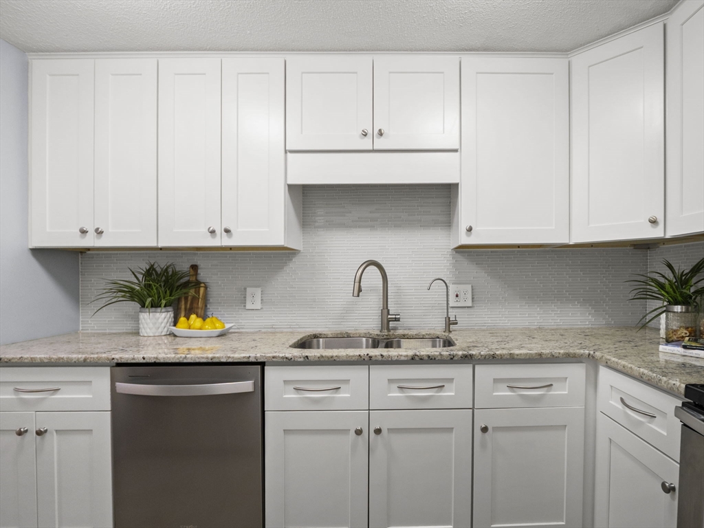 9 Elm Street, Unit 1 Acton, MA 01720 - Photo 10 of 29 a kitchen with stainless steel appliances granite countertop white cabinets sink and a granite counter tops