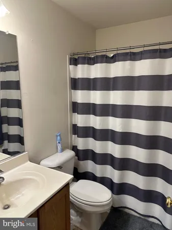 a bathroom with a sink a toilet a mirror and shower