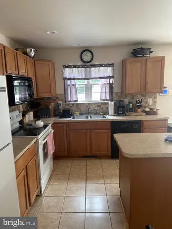 a kitchen with a sink a stove top oven and cabinets