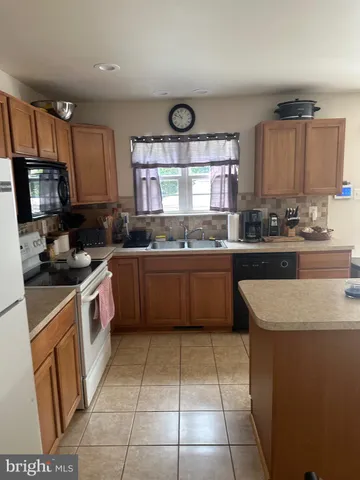 a kitchen with a sink a stove top oven and cabinets