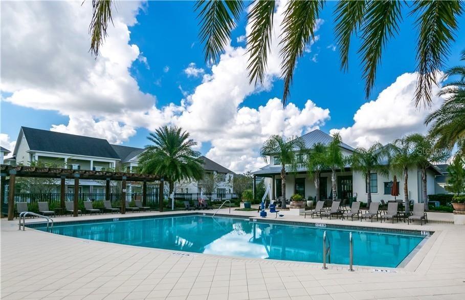 1515 Resolute Street Celebration, FL 34747 - Photo 38 of 39 a view of a swimming pool with a table and chairs potted plants and palm trees