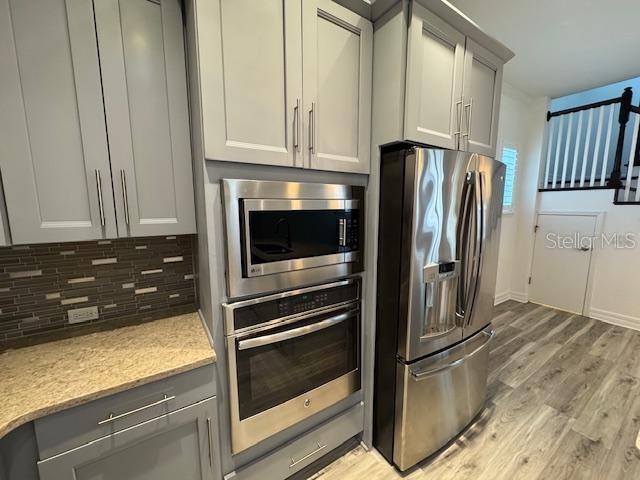 1515 Resolute Street Celebration, FL 34747 - Photo 9 of 39 a kitchen with granite countertop a refrigerator and cabinets