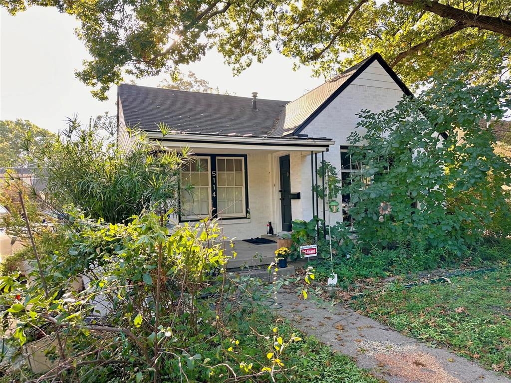 front view of house with a yard and potted plants